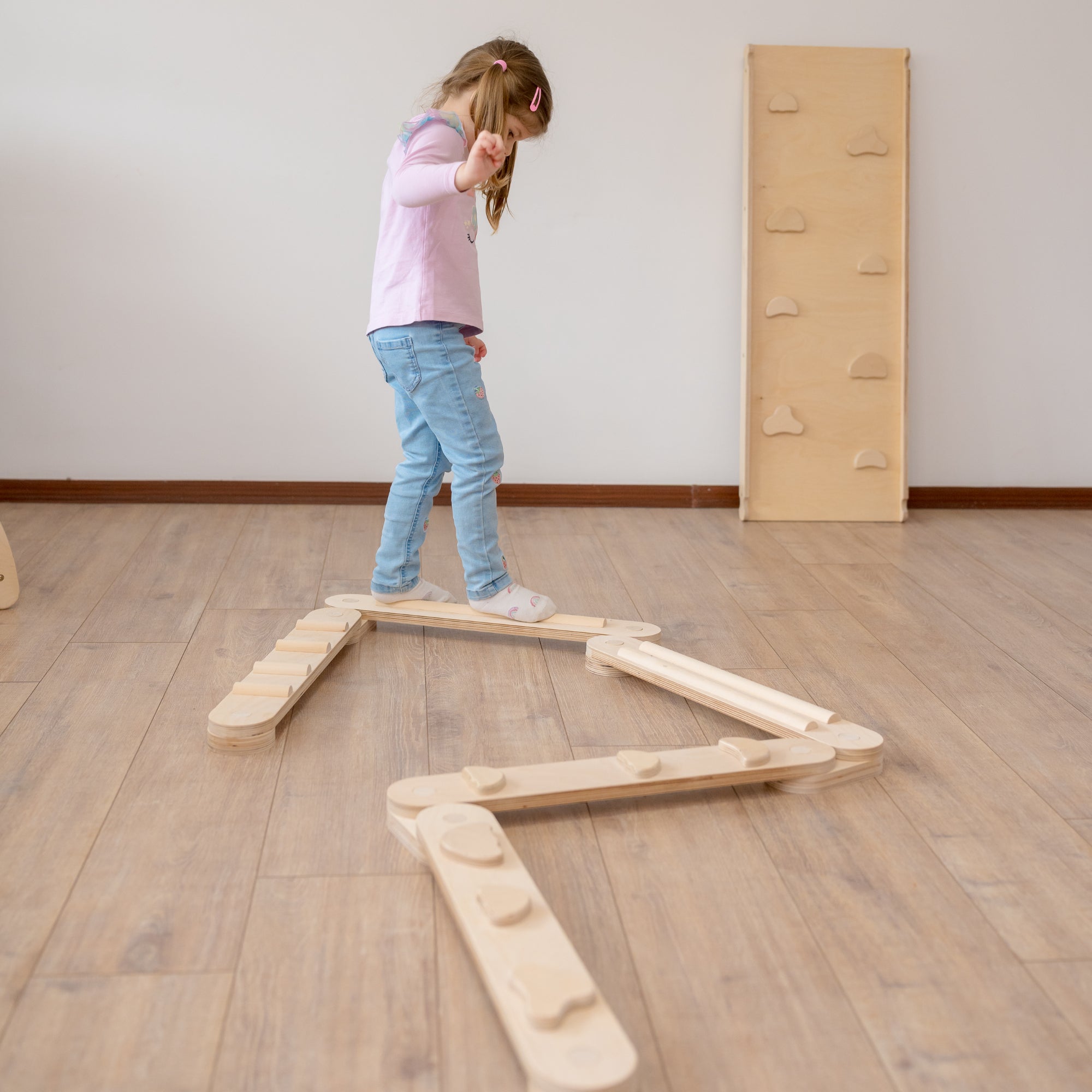 Kind balanciert auf dem CLIFF Balance Balancebalken aus Holz