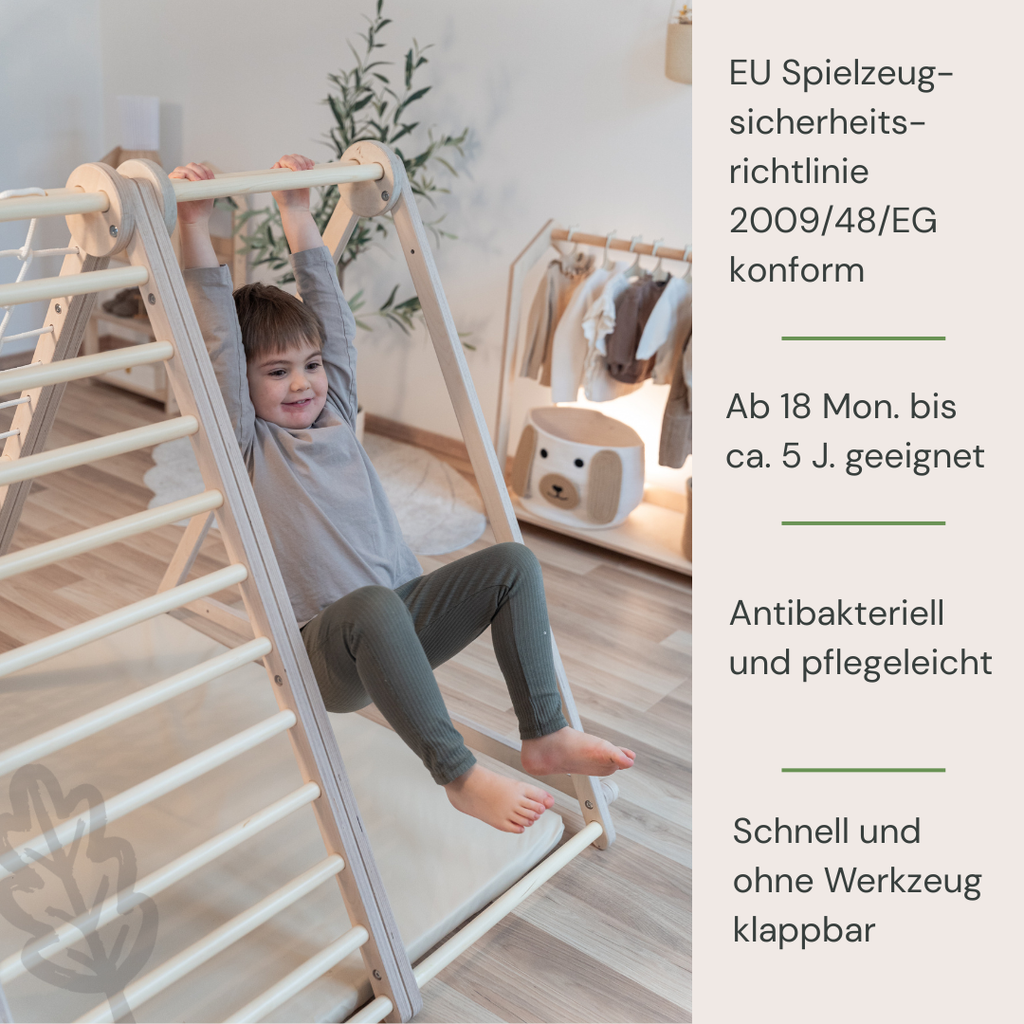 Kind spielt am CLIFF FLEX White Edition Klettergerüst mit Premium-Matte im Kinderzimmer +  EUrichtlinie