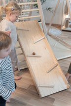 Kinder spielen mit der CLIFF Rutschrampe als Kugelbahn am Indoor-Klettergerüst