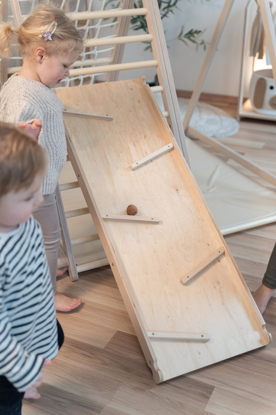 Kinder spielen mit der CLIFF Rutschrampe als Kugelbahn am Indoor-Klettergerüst