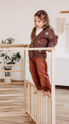 Kind balanciert am CLIFF PRO Indoor-Klettergerüst aus Holz