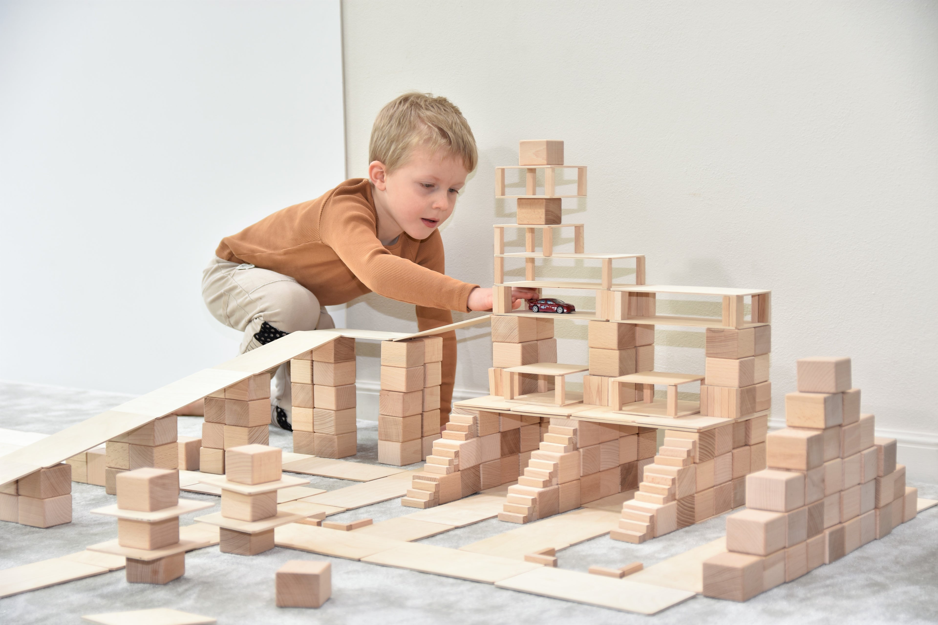 Kind spielt mit Just Blocks BASIC Big und baut eigene Holzkonstruktionen