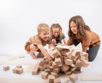 Drei Kinder spielen gemeinsam mit dem Just Blocks BASIC Big Holz-Lernsystem