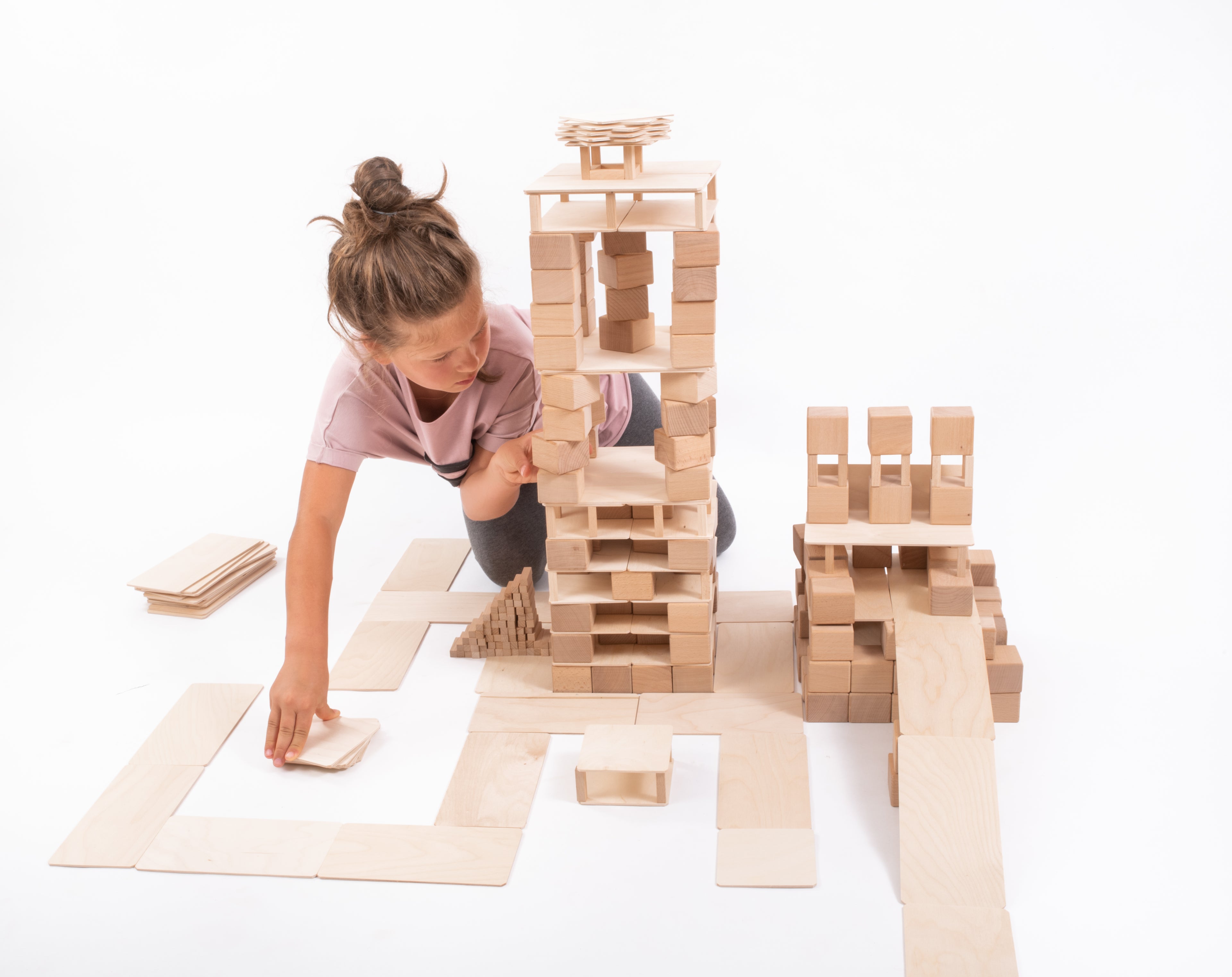 Kind baut mit dem Just Blocks BASIC Big Holz-Lernsystem aus vielen Holzelementen