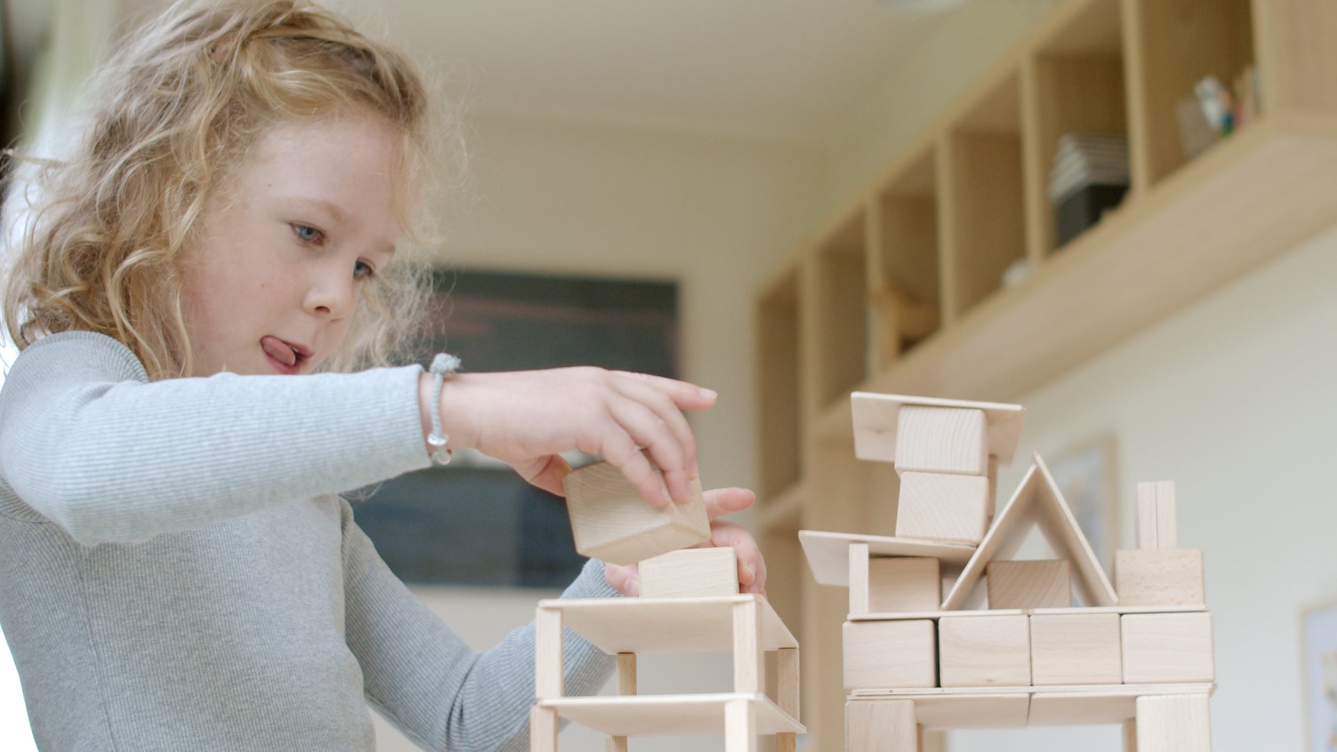 Kind spielt mit dem Just Blocks BASIC Small Holz-Lernsystem