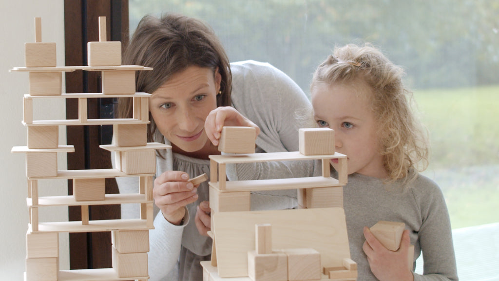 Frau und Kind bauen gemeinsam mit Just Blocks BASIC Medium Holzelementen