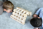 Kinder betrachten eine grosse Brücken-Bauidee aus Just Blocks Balance Tower Group Challenger Holzelementen