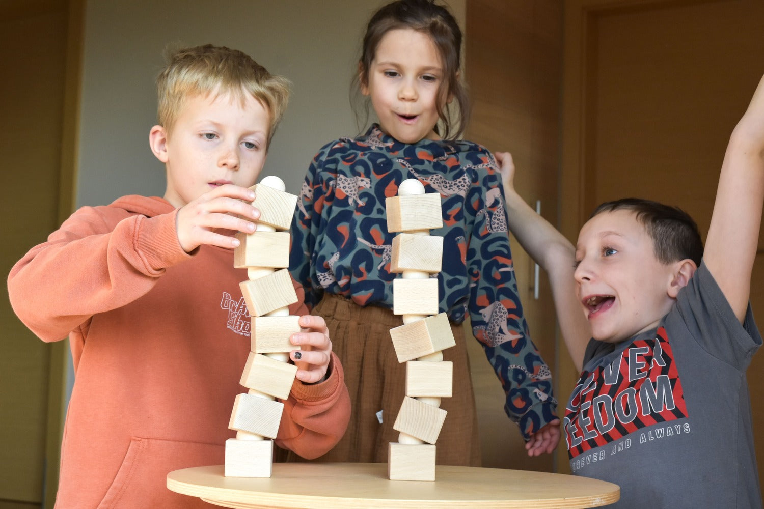 Kinder spielen gemeinsam mit dem Just Blocks Balance Tower Master Holz-Balancespiel