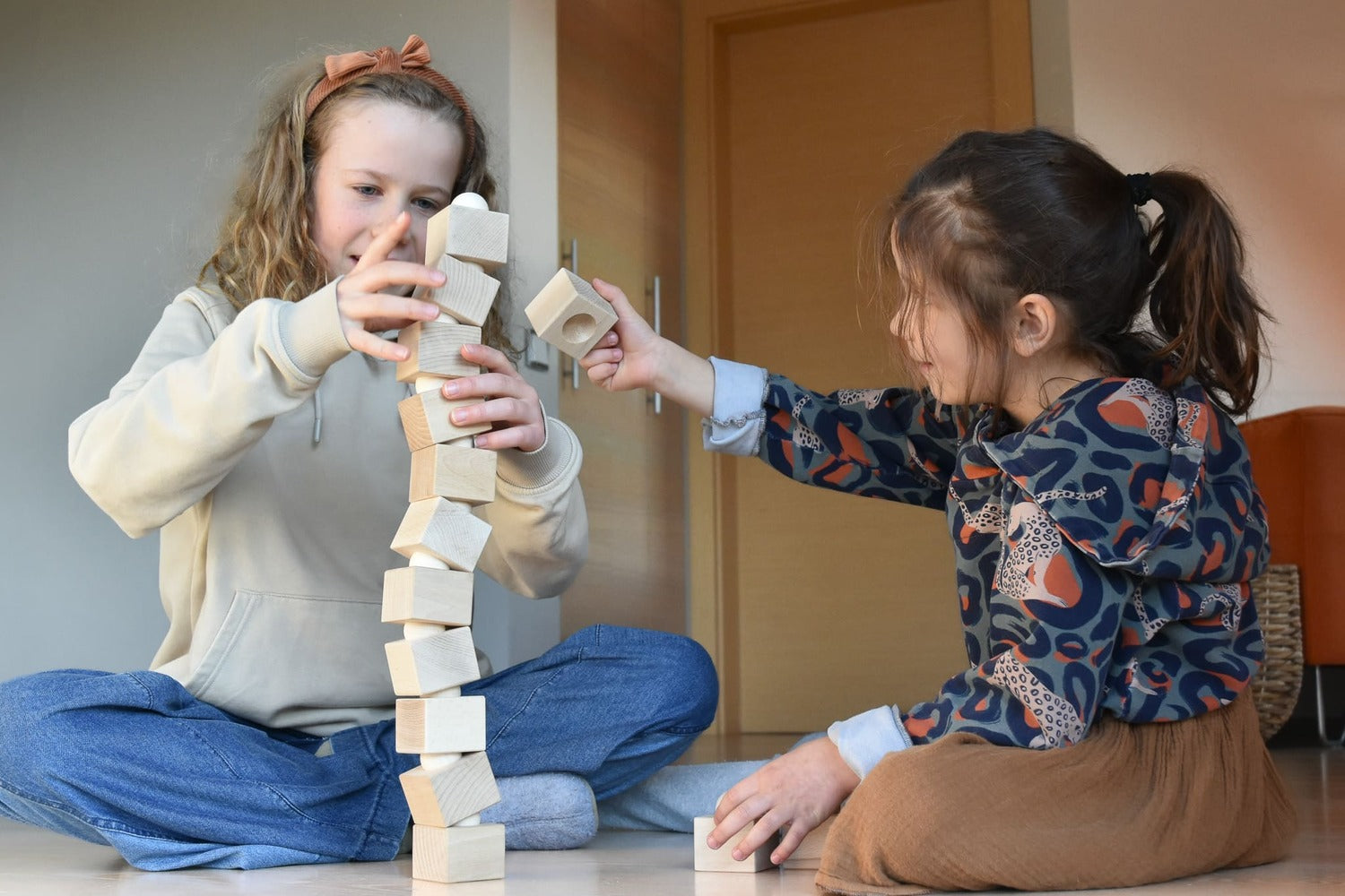 Kinder bauen gemeinsam einen hohen Turm mit dem Just Blocks Balance Tower Master