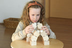 Kind baut mit dem Just Blocks Balance Tower Master mehrere balancierende Holzkonstruktionen