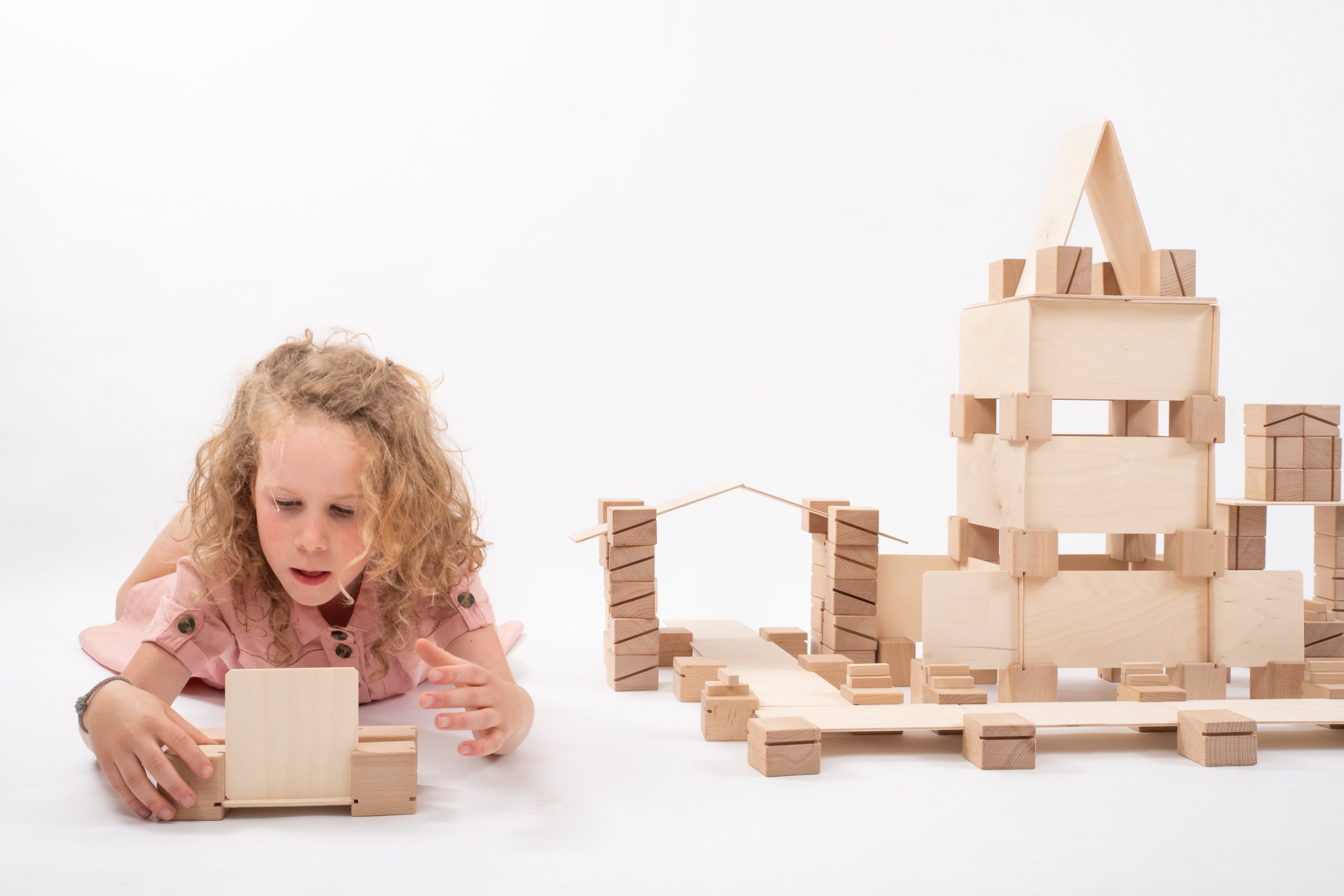 Kind spielt mit dem Just Blocks Smart Lines 160-teiligen Holz-Lernsystem